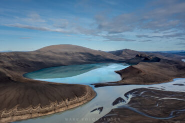 Turquoise blue lake on the edge of a highland river
